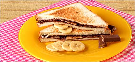 Chocolate banana toast sandwich with nido milk powder served on plate