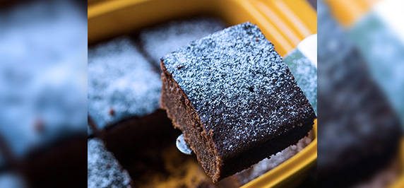 Chocolate brownie dusted with sugar served in tray