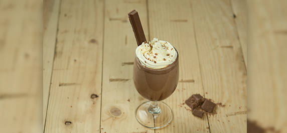 Chocolate milkshake with nestle everyday milk topped with whipped cream and chocolate pieces