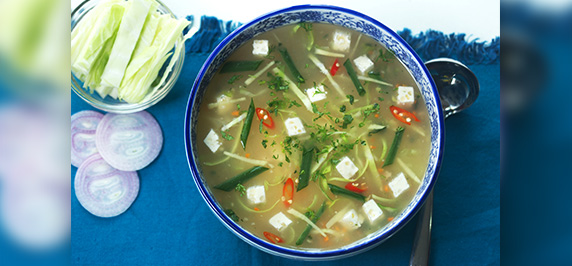 Vegetable soup with cabbage cheese cubes and herbs
