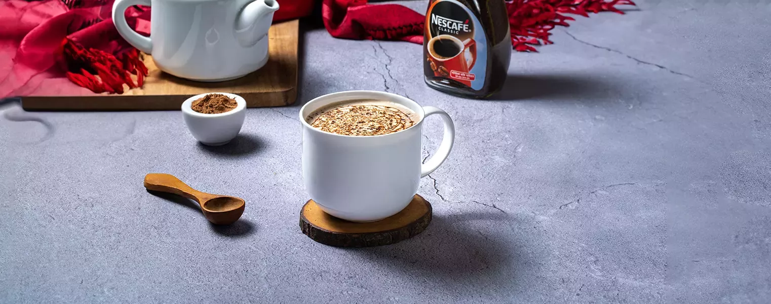 Hot chocolate with nescafe coffee topped with cocoa powder in white mug